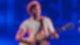 Max Giesinger sitzt vor einem blauen Hintergrund auf der RSH Bühne mit seiner Gitarre