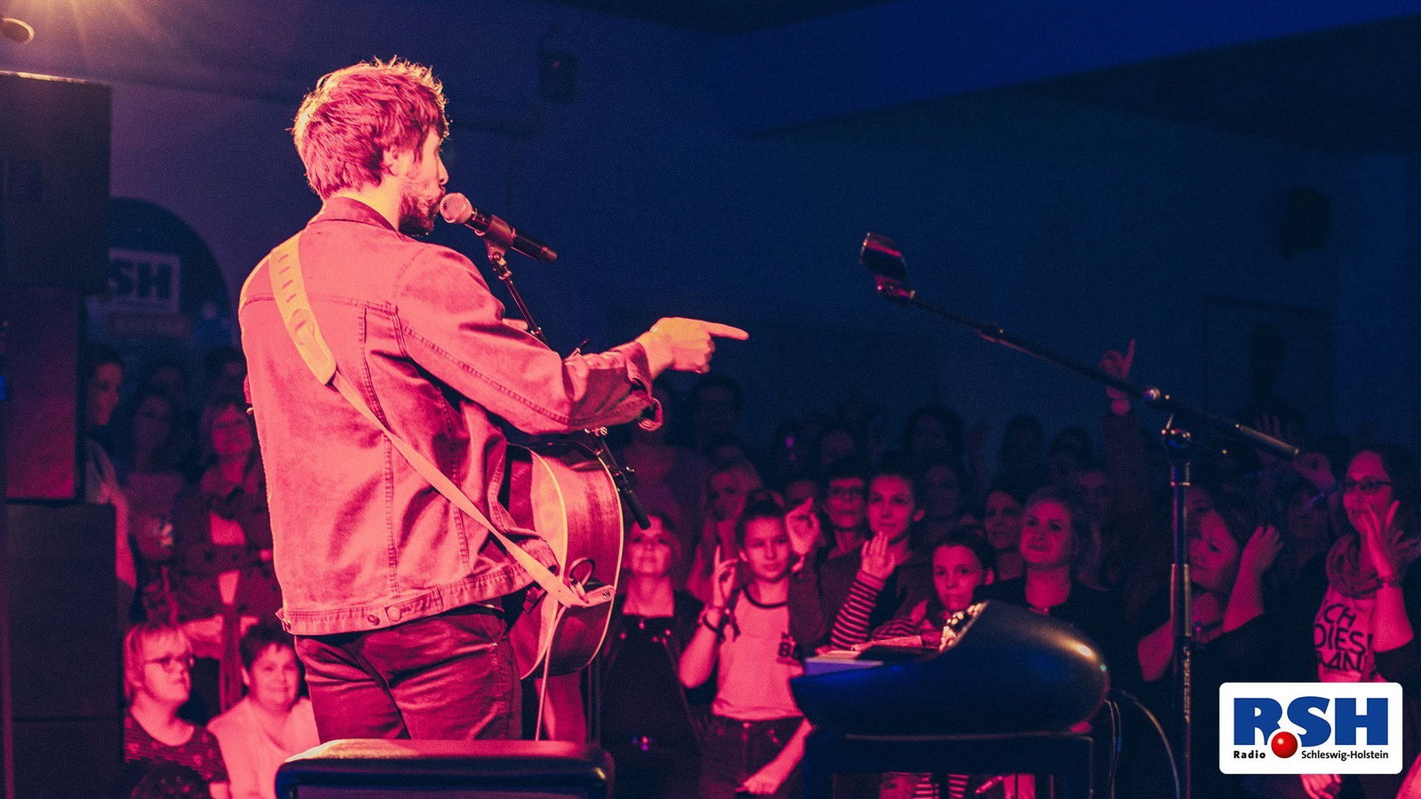 Max Giesinger steht auf der Bühne und das Publikum ist zu sehen.