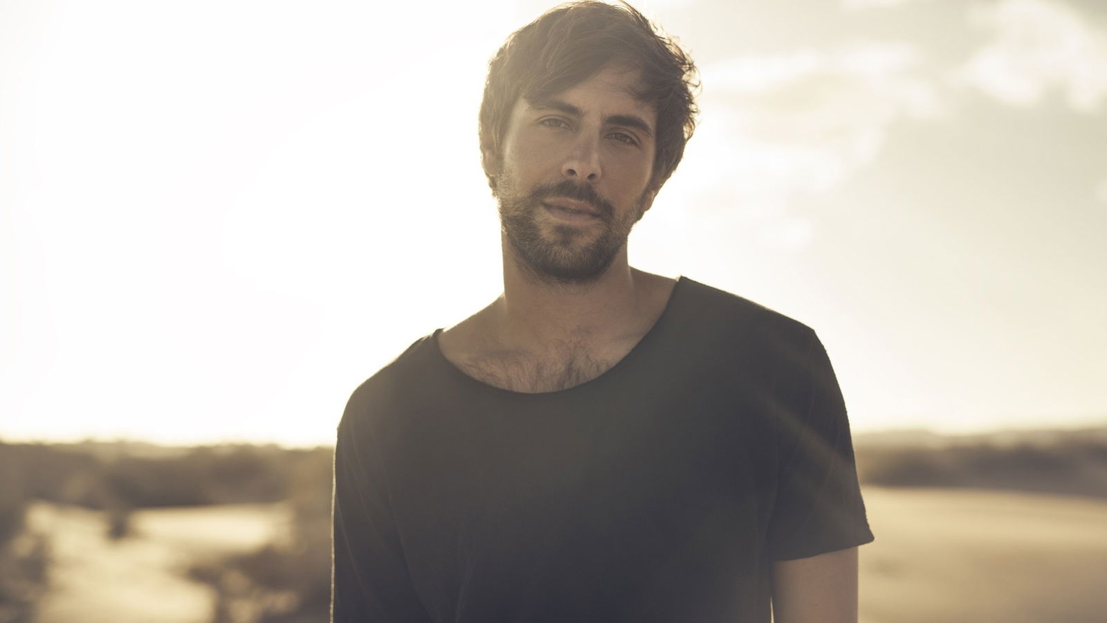 Max Giesinger steht vor einem Sonnenuntergang.