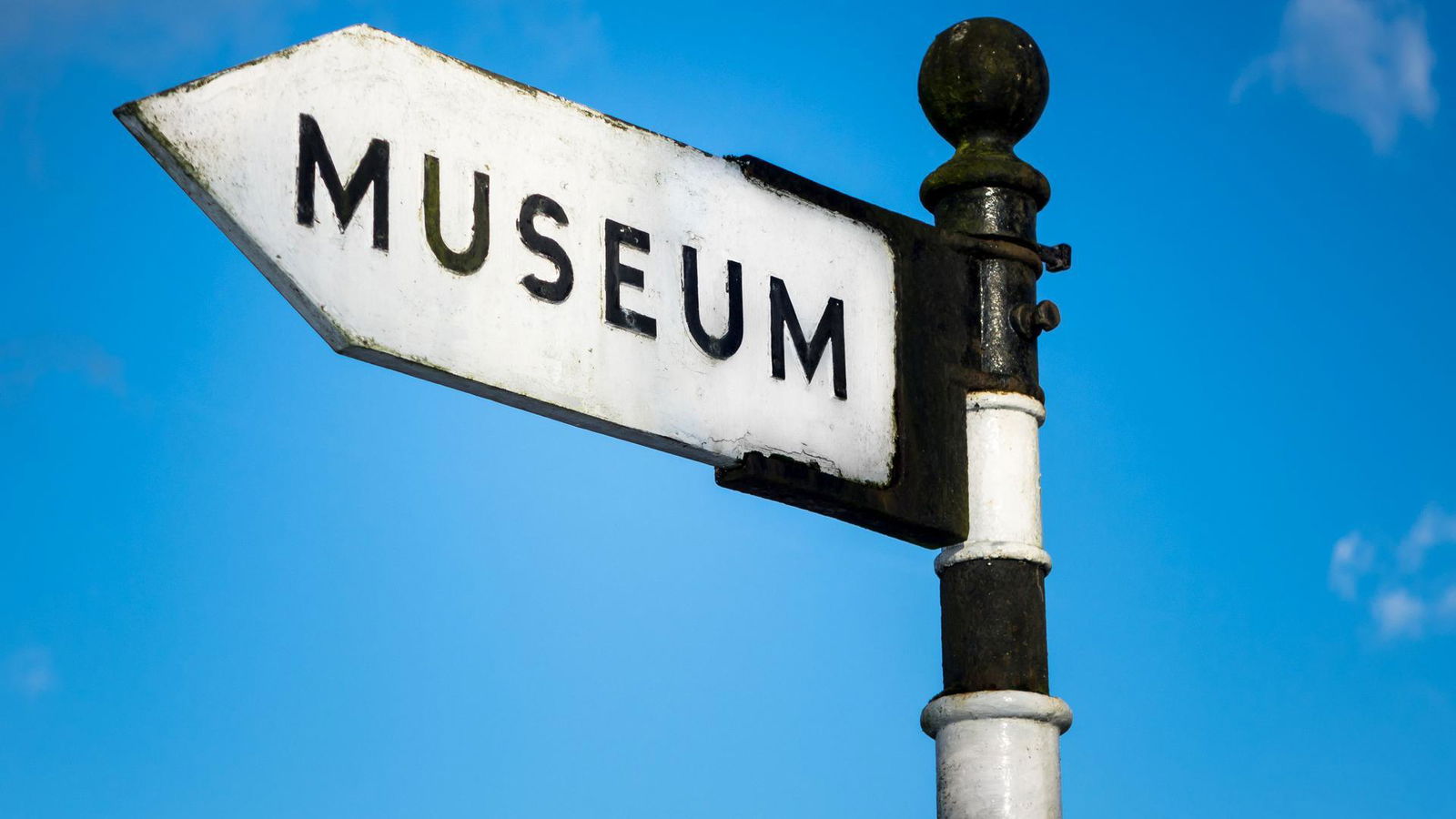 Ein schwarz weißes Schild auf dem "Museum" drauf steht.
