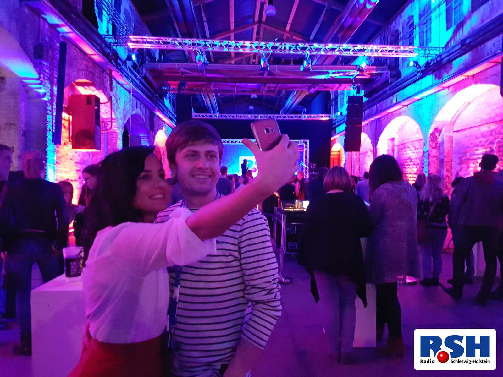 Zwei Besucher machen ein Selfie in der Location.