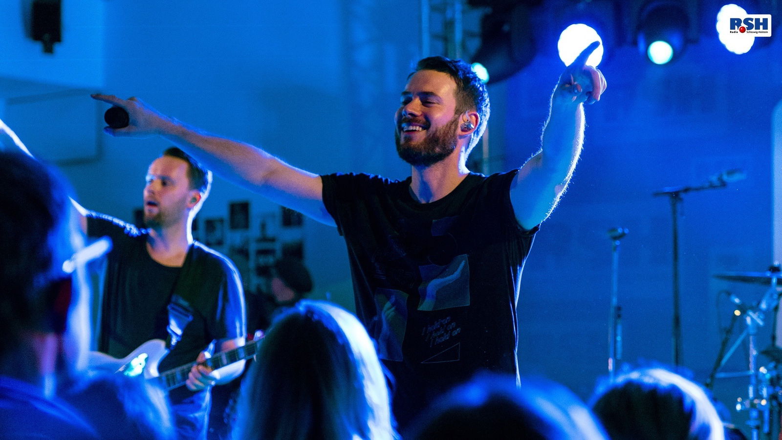 Johannes Strate lächelt auf der Bühne.