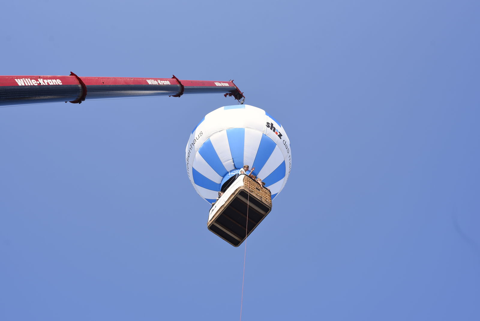 Ein Heißluftballonmodell wird an einem Kran in die Luft gehoben.