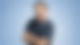 Frank Bremser steht vor einem blauen Hintergrund und lächelt in die Kamera.
