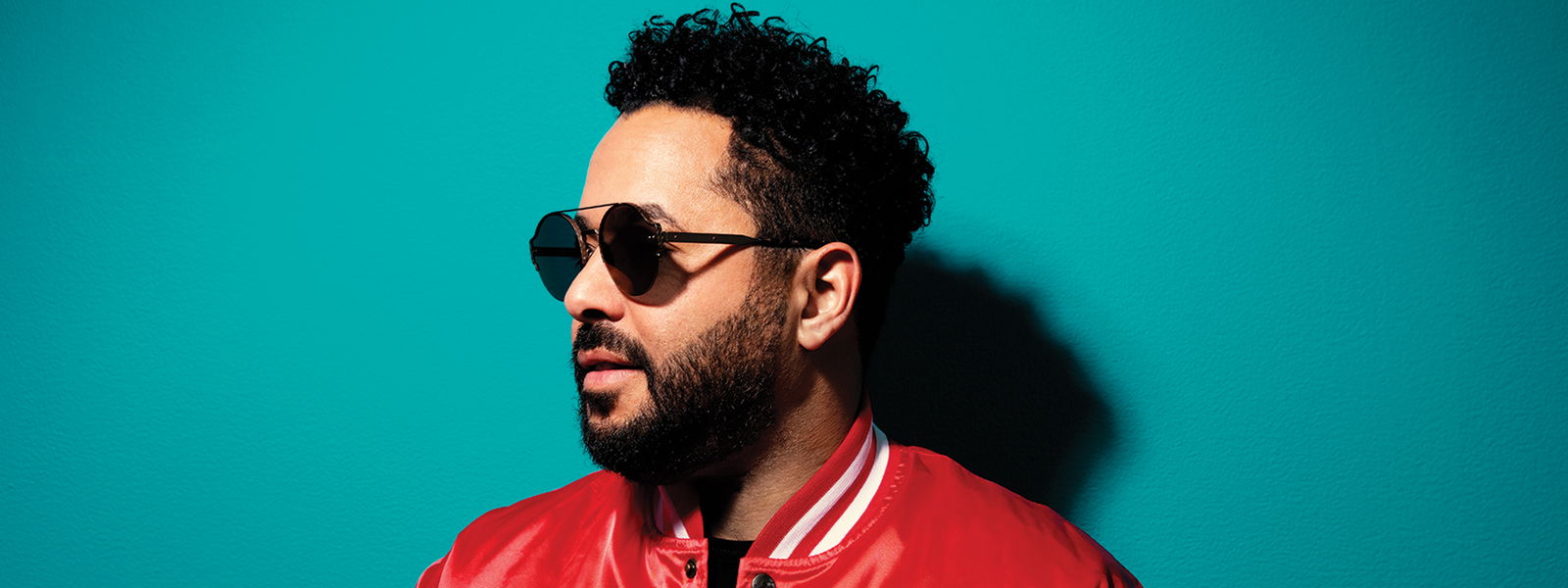 Sänger Adel Tawil steht vor einer Wand und hat eine Sonnenbrille auf