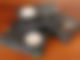 Auf einem Holztisch liegen drei Videokassetten. Die eine Kassette liegt auf den anderen beiden drauf.