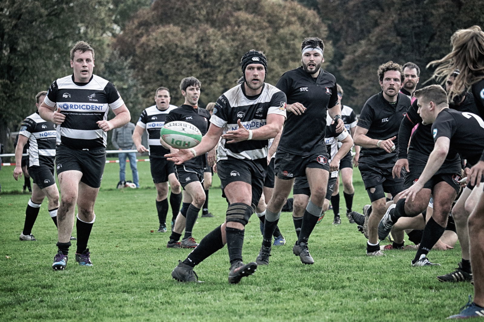 Zwei Rugbyteams spielen gegeneinander auf dem Feld.