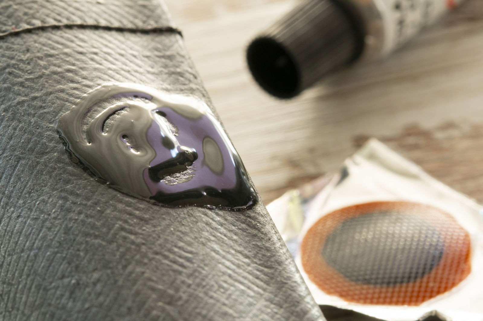 Ein Fahrradschlauch liegt auf einem Tisch und wird geflickt.