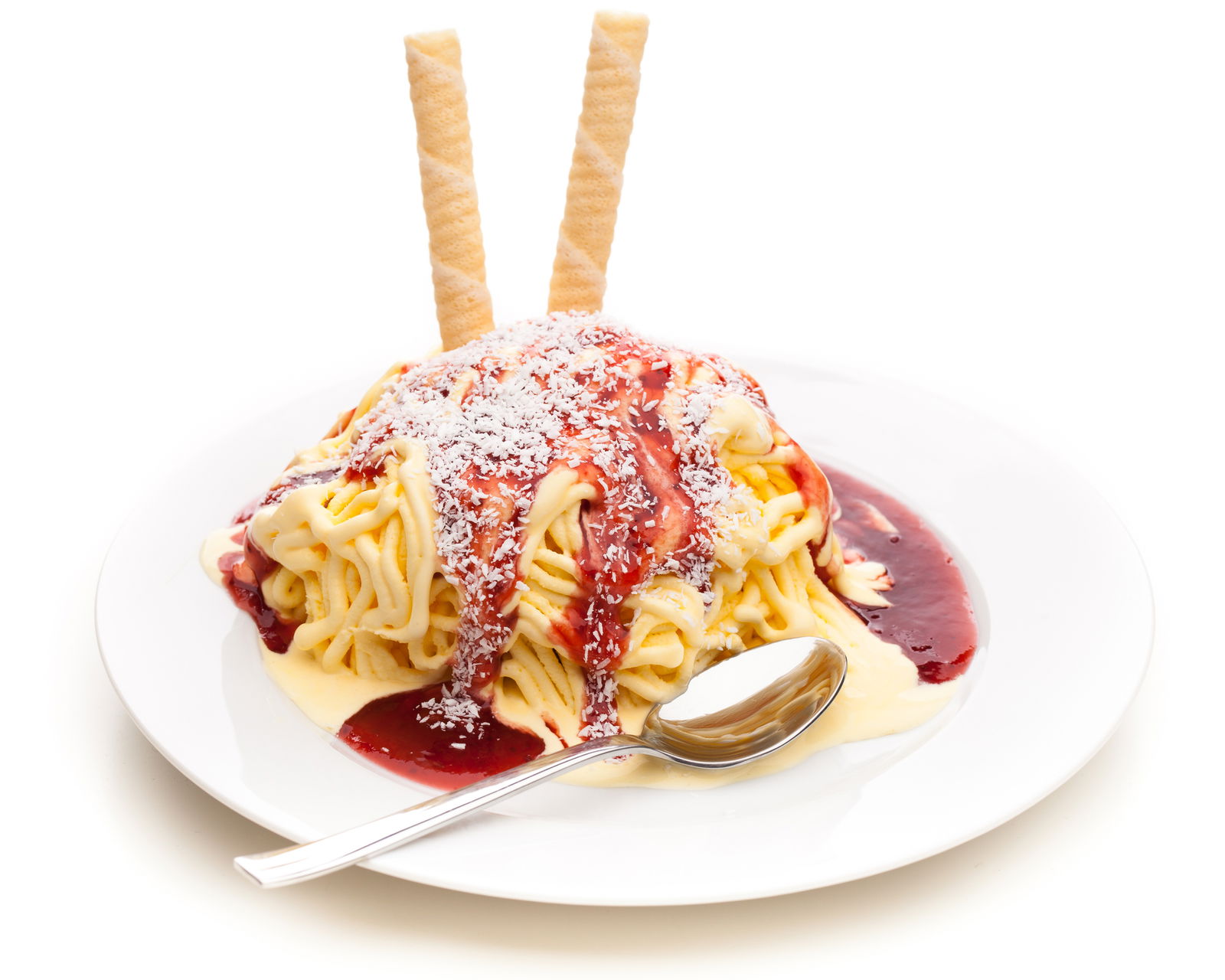 Auf einem Teller liegt ein Spagetti-Eis mit Löffel, begossen mit Erdbeersoße und zwei Waffeln darin steckend.