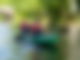 Zwei Menschen in einem grünen Kajak fahren über einen Fluss.