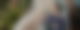 Eine junge Frau liegt in einer Hängematte und schaut auf ihr Smartphone, das sie in der rechten Hand hält.