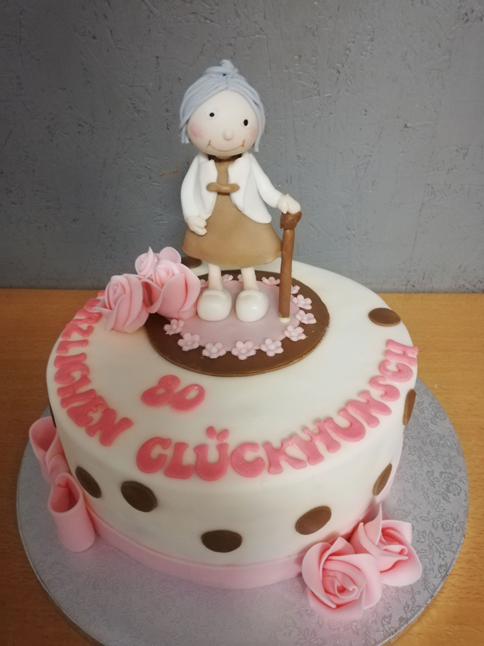 Eine weiße Torte mit rosa und braunen Details