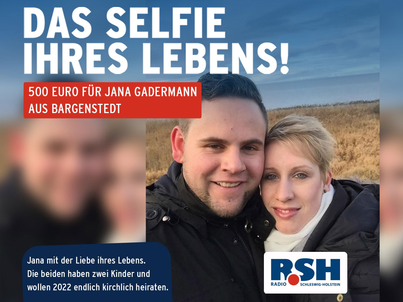 Ein Mann und eine Frau stehen eng nebeneinander vor Dünen und lächeln.