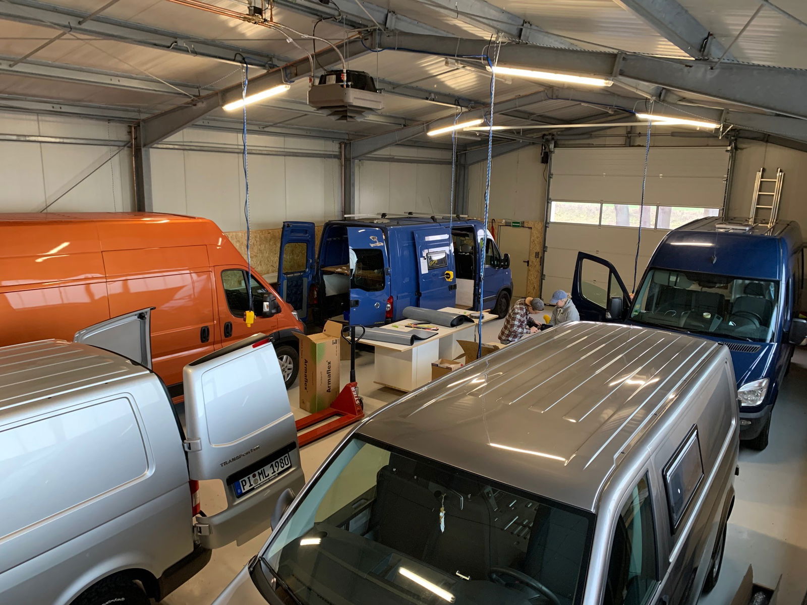 Mehrere Vans stehen in einer großen Halle.