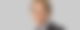 Ministerpräsident Daniel Günther schaut vor grauem Hintergrund gerade in die Kamera.