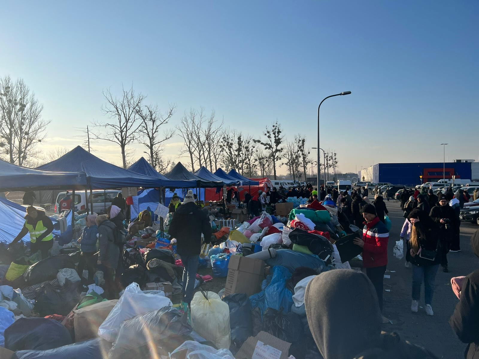 Unter einem Pavillon liegen viele verschiedene Dinge in Kisten und Säcken verstreut.
