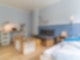 Ein helles und modernes Zimmer mit Schreibtisch, Sofa und Tisch.