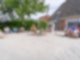 Vor einem Haus sitzen mehrere Menschen in Strandkörben und auf Stühlen in der Sonne.
