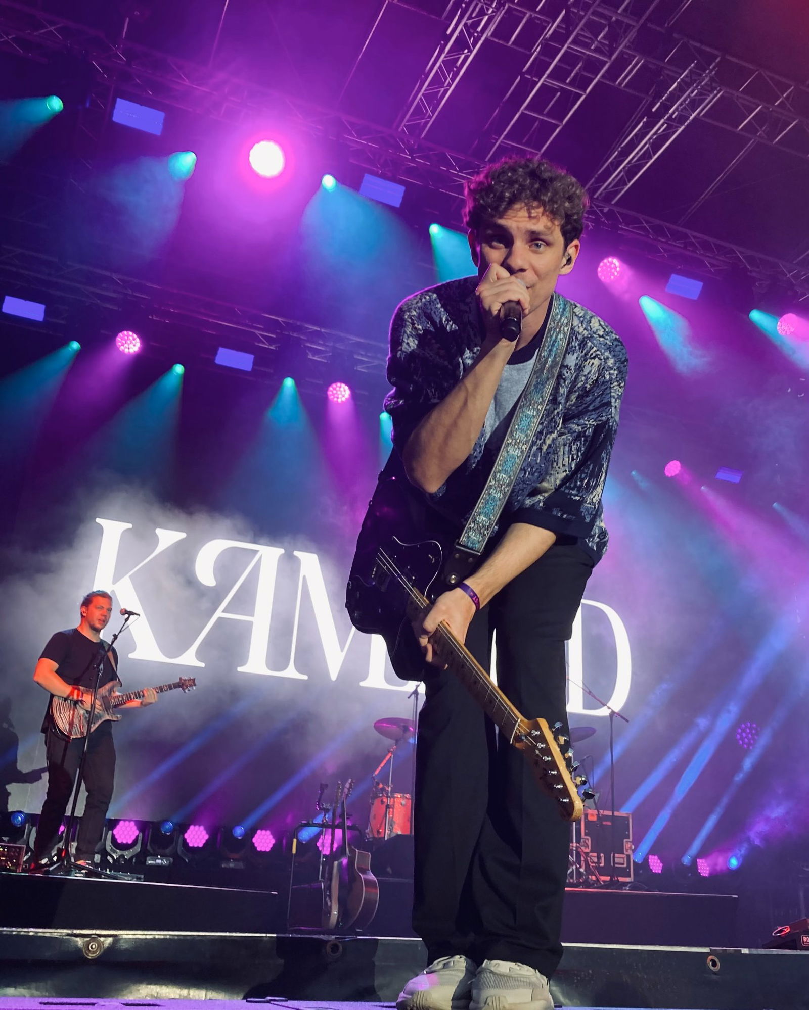 Tim Kamrad singt mit Mikrofon in die Kamera.