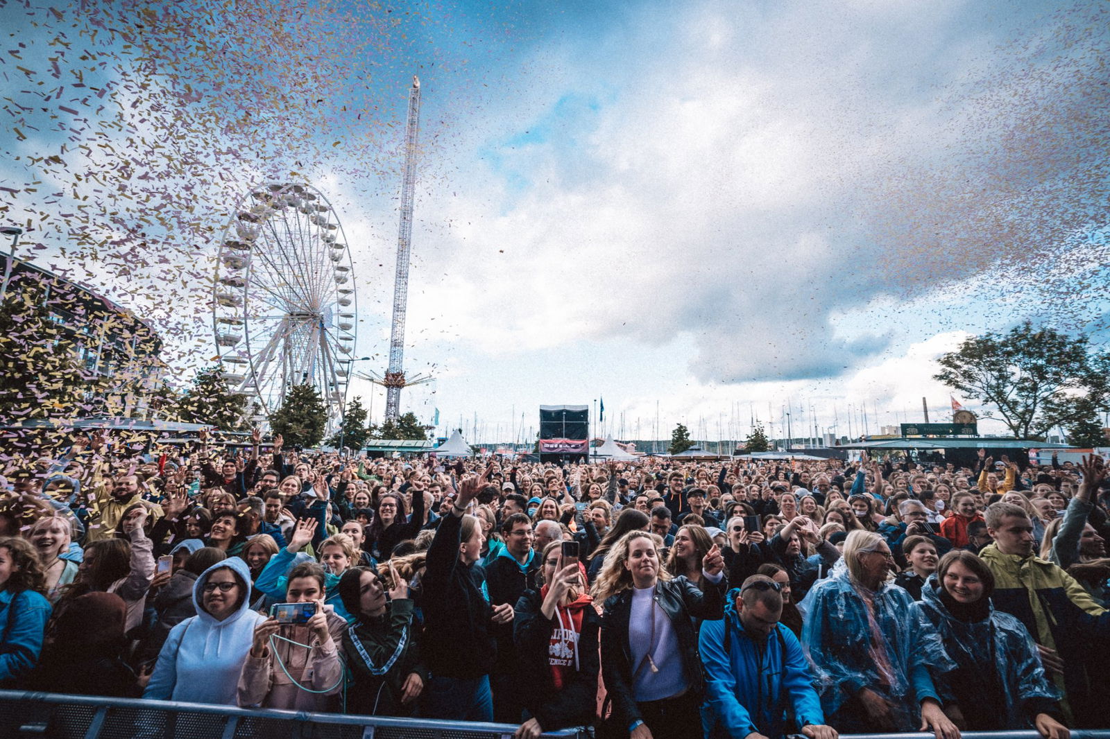 Tanzende Menschen und im Hintergrund ein Riesenrad.