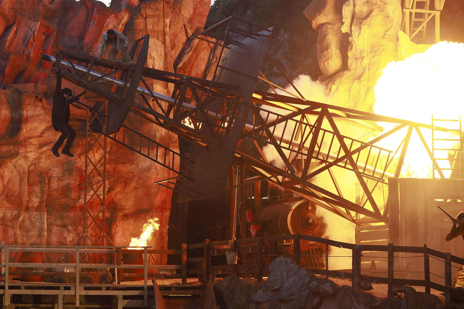 Ein Mann hängt an einem brennenden Ölturm.