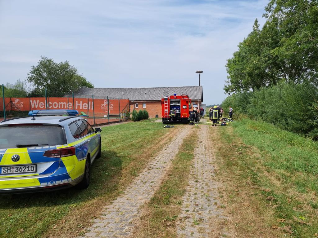 Auf einem Weg stehen ein Polizei-Auto und ein Feuerwehr-Auto.