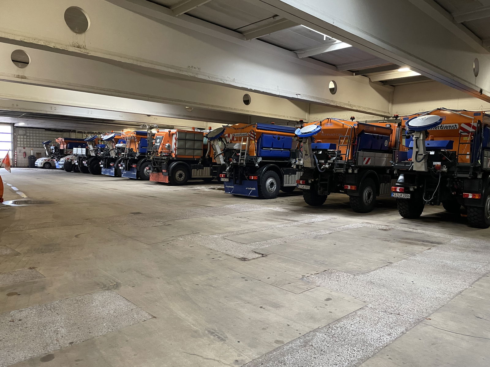 Mehrere Streufahrzeuge stehen in einer Garage