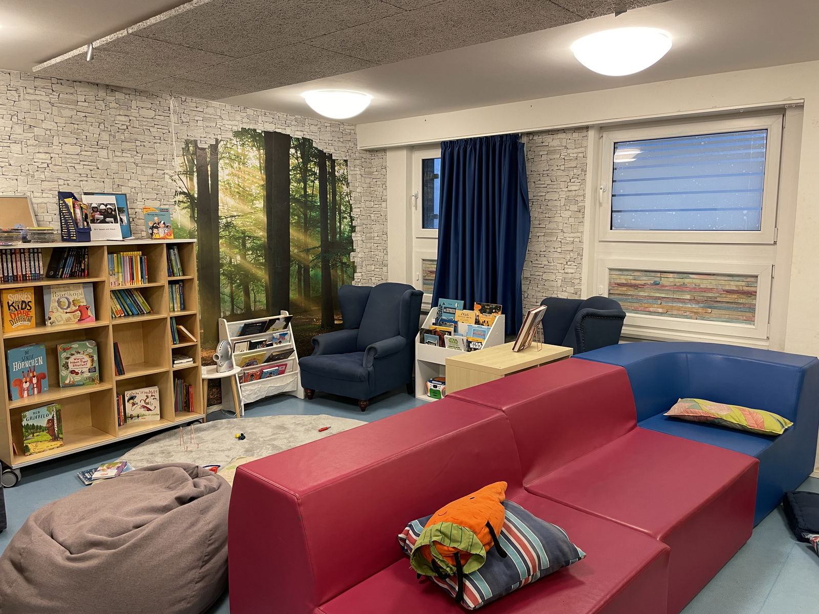 Ein Spieleraum mit Sofas, Sesseln und Bücherregalen