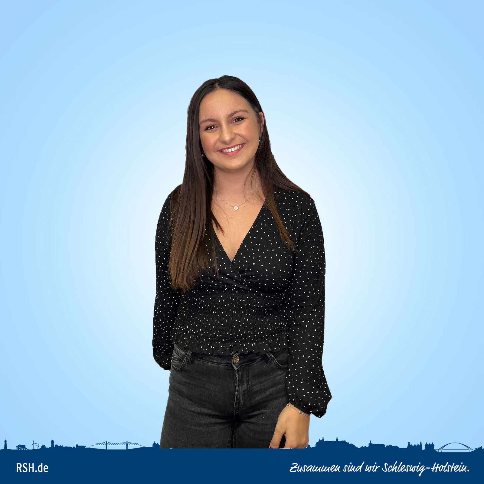 Melissa Yilmaz steht vor einem blauen Hintergrund und lächelt in die Kamera