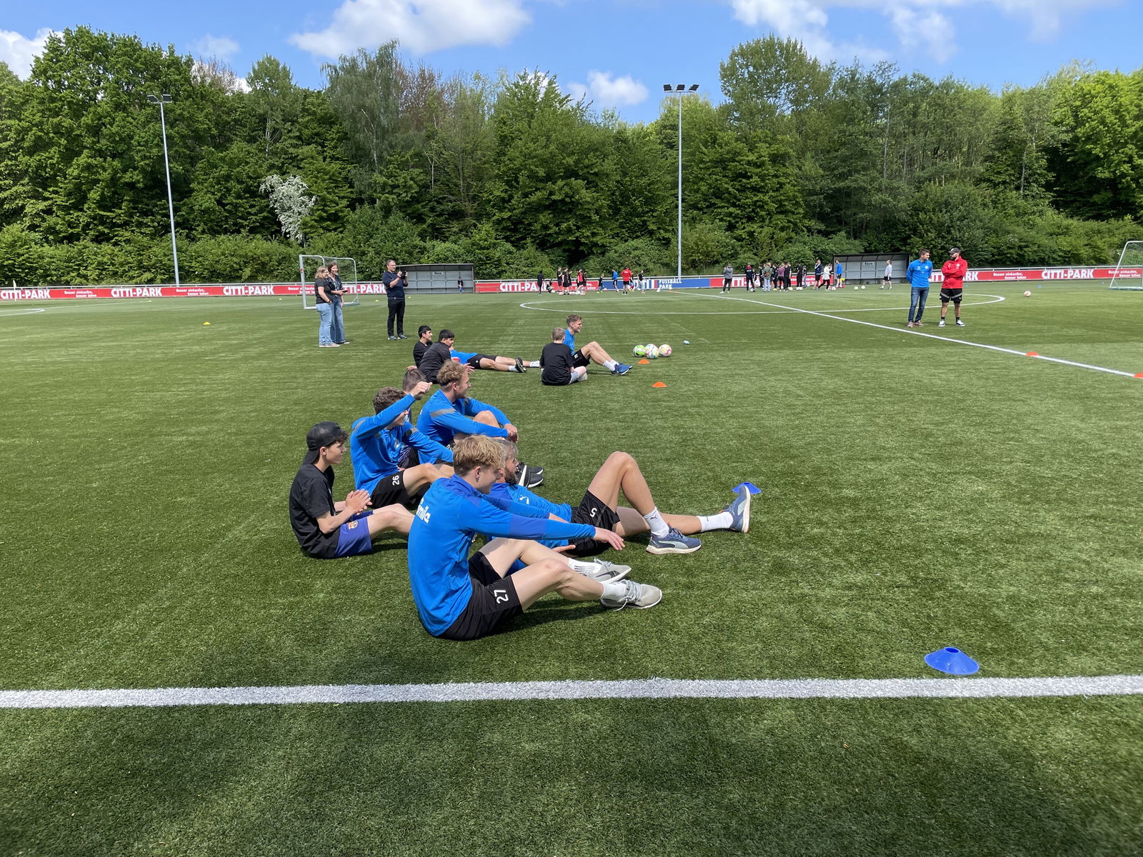 Fußballspieler sitzen auf dem Rasen