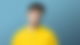 Toby Romeo steht vor einem blauen Hintergrund und guckt in die Kamera.
