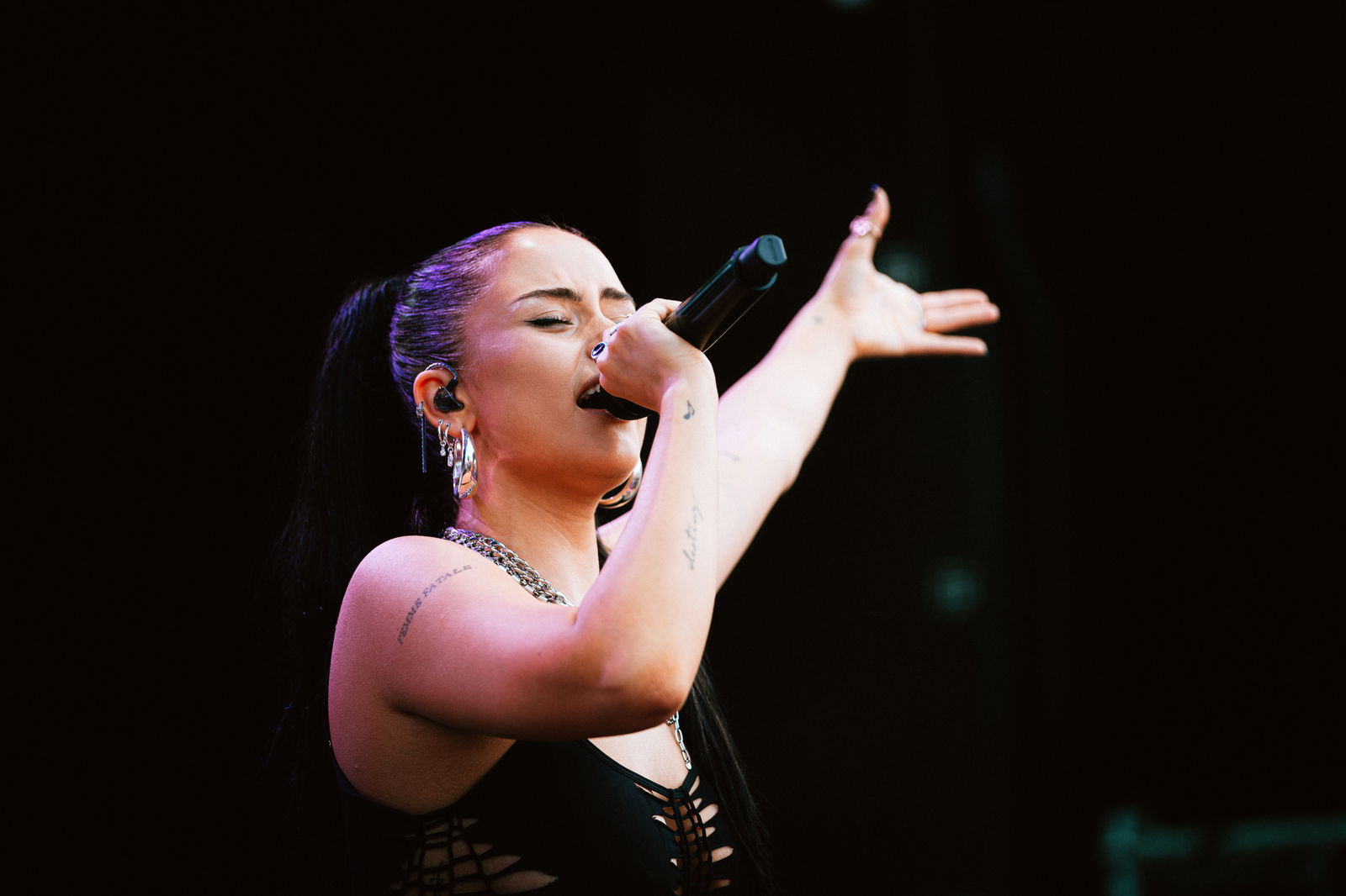 Anna Grey hält ein Mikrofon in der Hand und singt