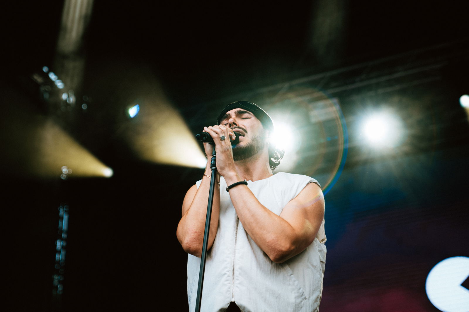 Ein Mann steht auf einer Bühne, hält ein Mikrofon und singt