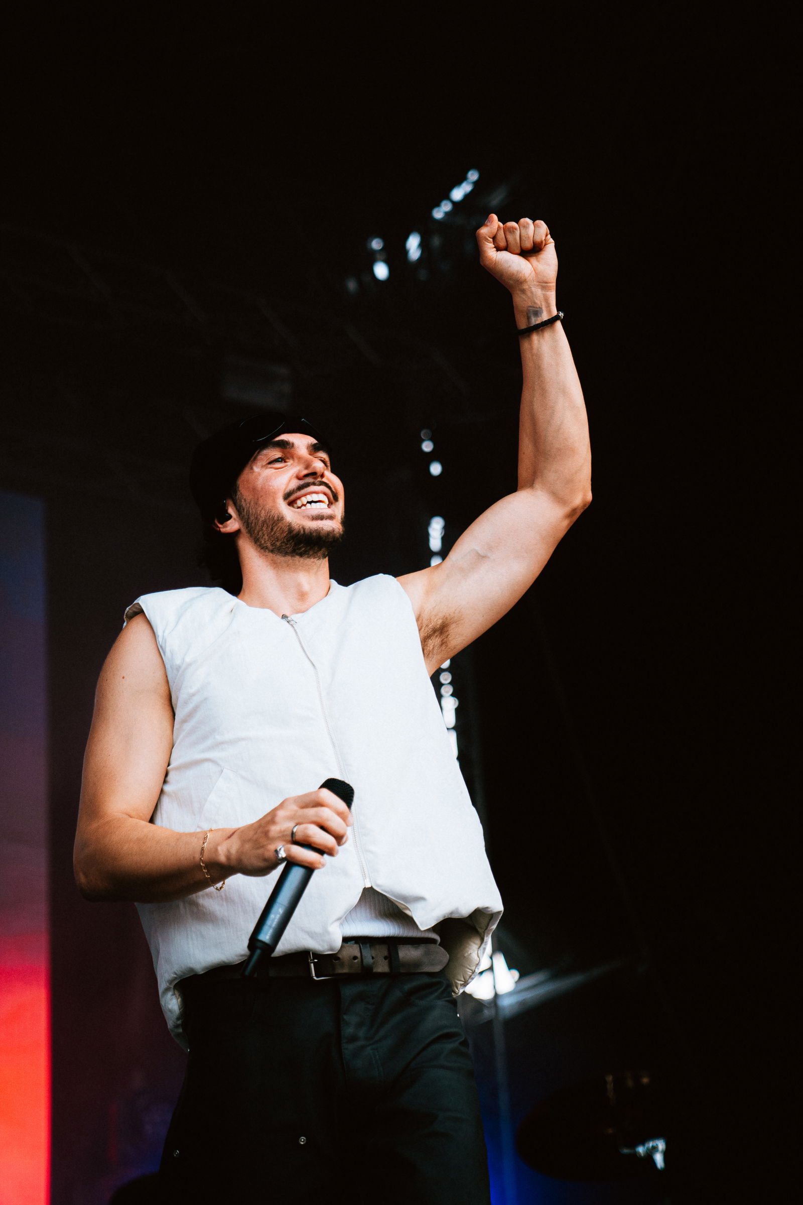 Ein Mann hält ein Mikrofon in der Hand und hebt die andere in die Höhe