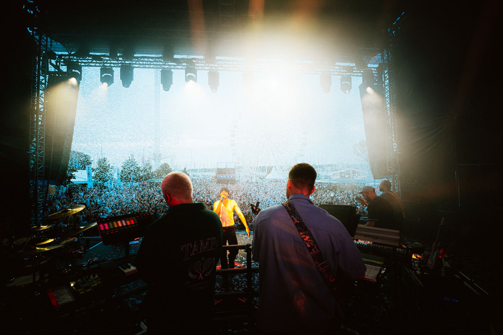 Die Band ClockClock steht auf einer Bühne und spielt vor einem großen Publikum