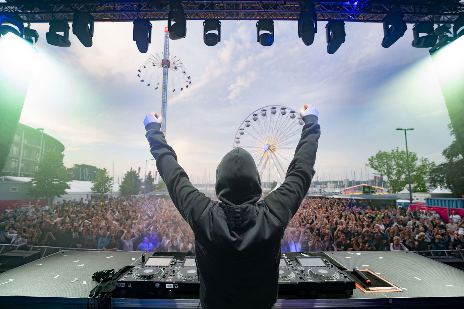 Glockenbach steht auf der Bühne und streckt die Hände in die Luft