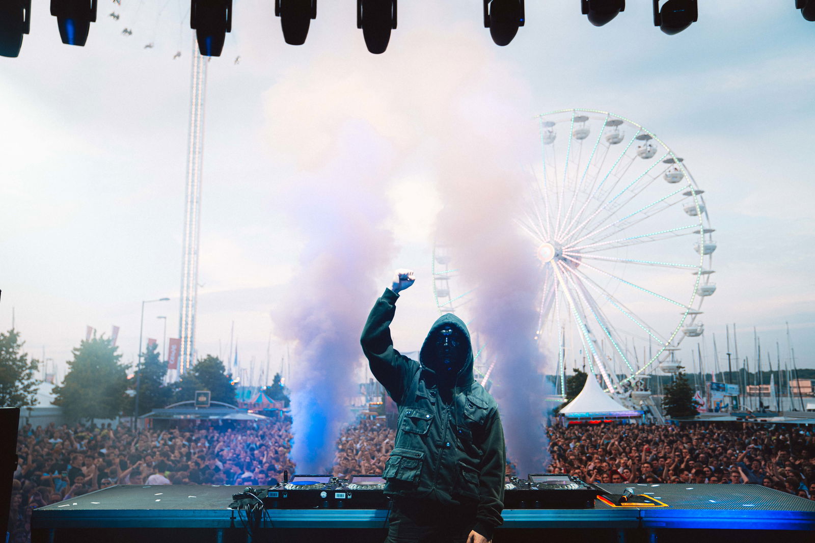 Glockenbach steht vor einer großen Menge auf der Bühne und streckt die Hand in die Luft