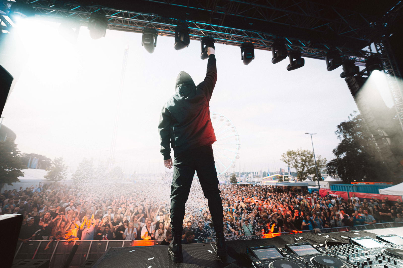 Glockenbach steht vor einem großen Publikum und streckt die Hand in die Luft.