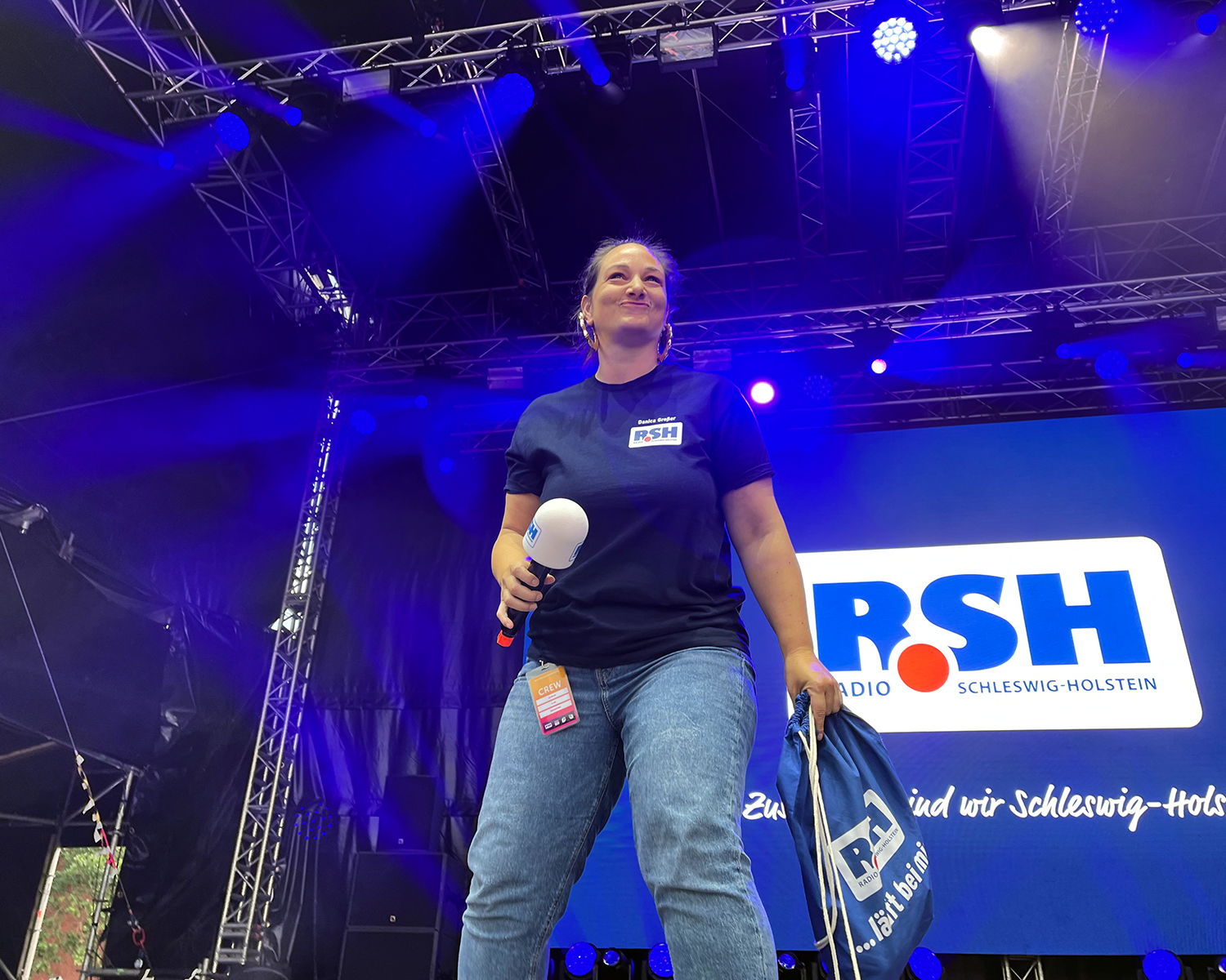 Danica Großer steht mit Mikrofon auf einer Bühne